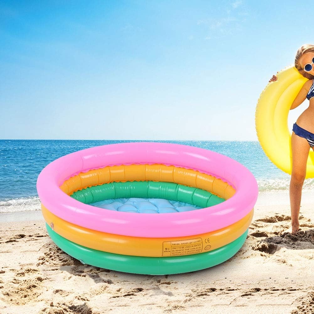 Piscina inflable arcoíris de 3 anillos para bebés, con fondo acolchado, en la playa.