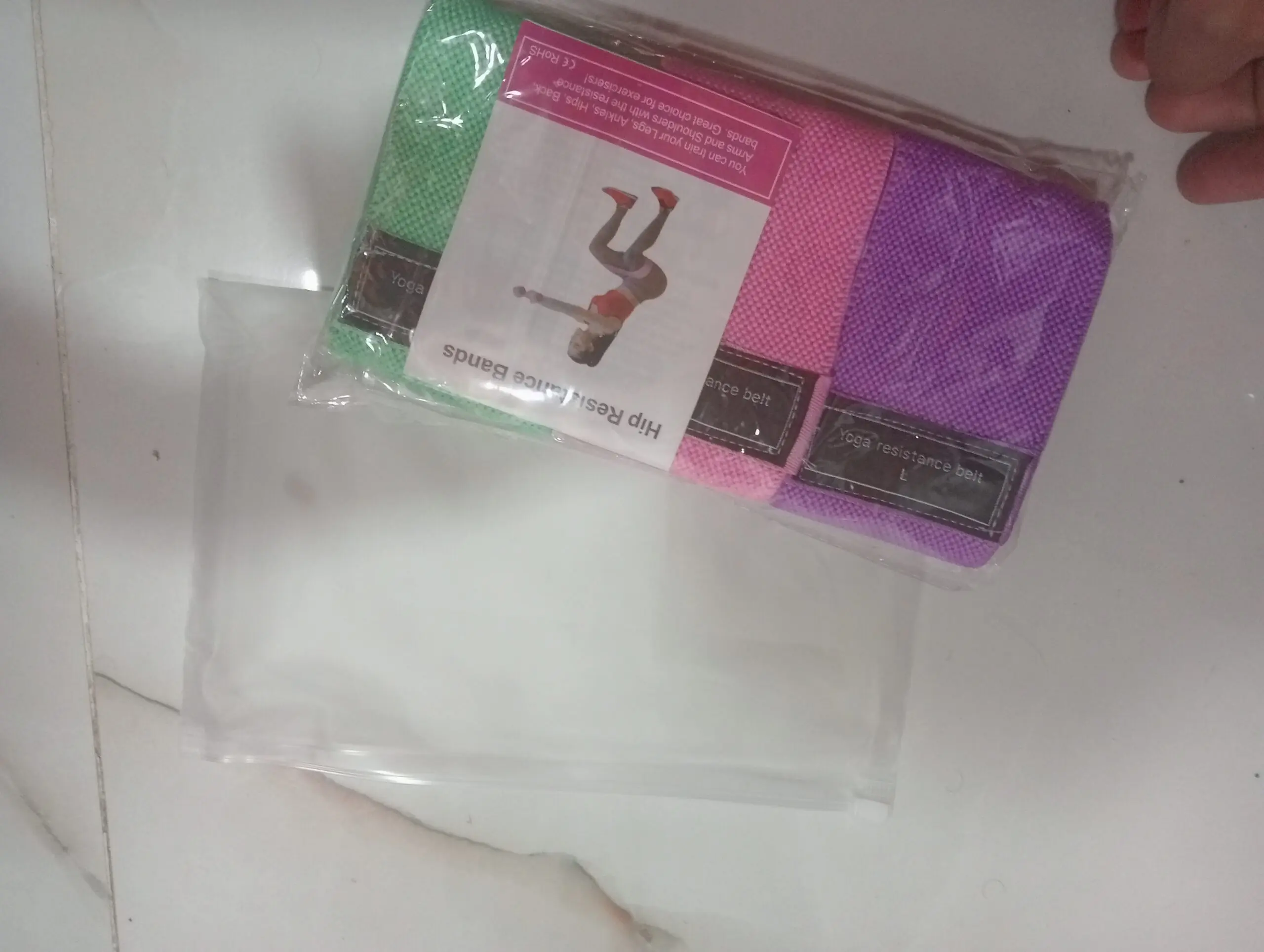 Bandas de resistencia de tela en verde, rosa y morado, para yoga y entrenamiento de glúteos y piernas.