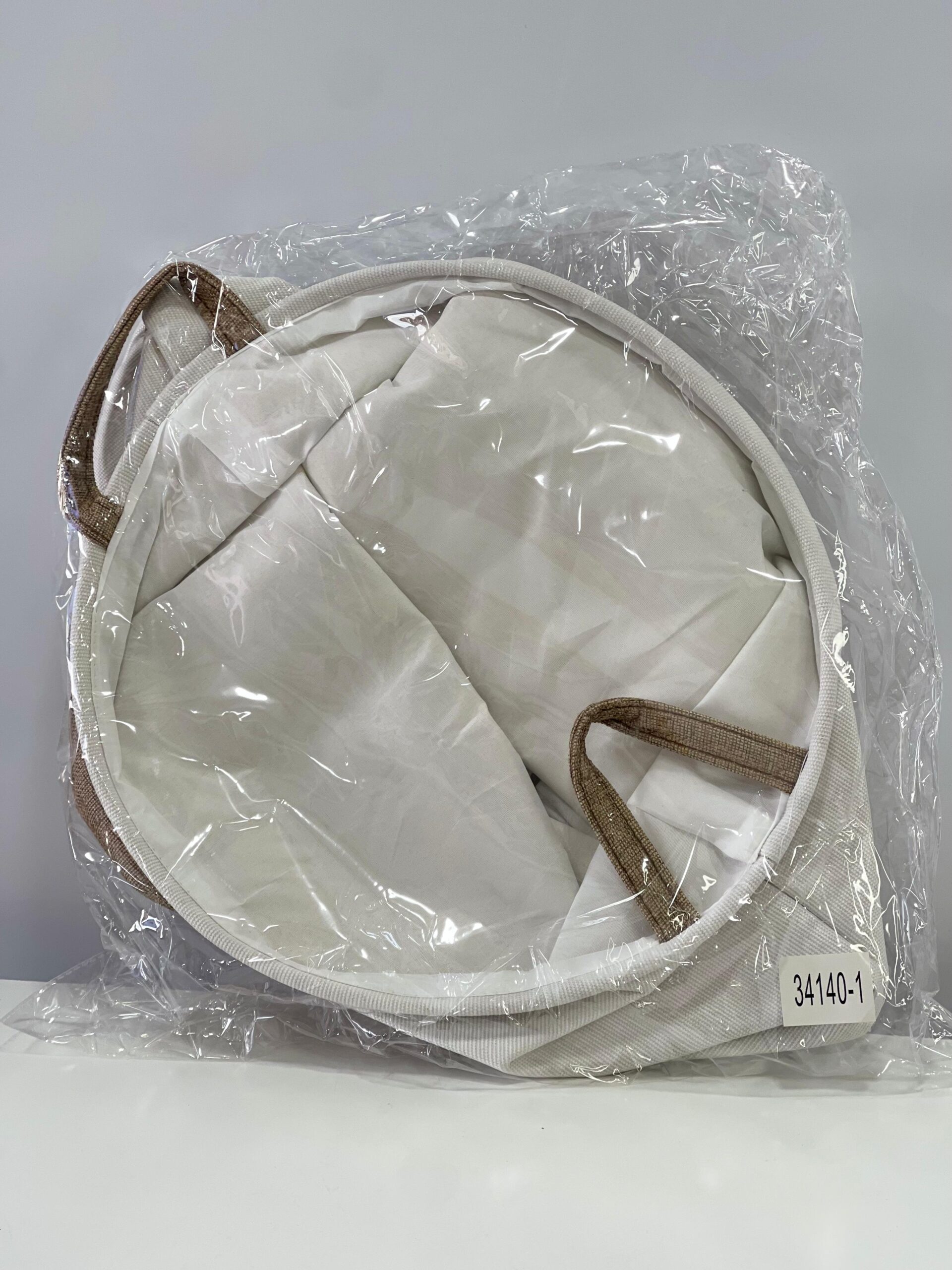 Cesto de ropa sucia de tela gris y blanco, con asas, en empaque plástico. Etiqueta "34140-1".