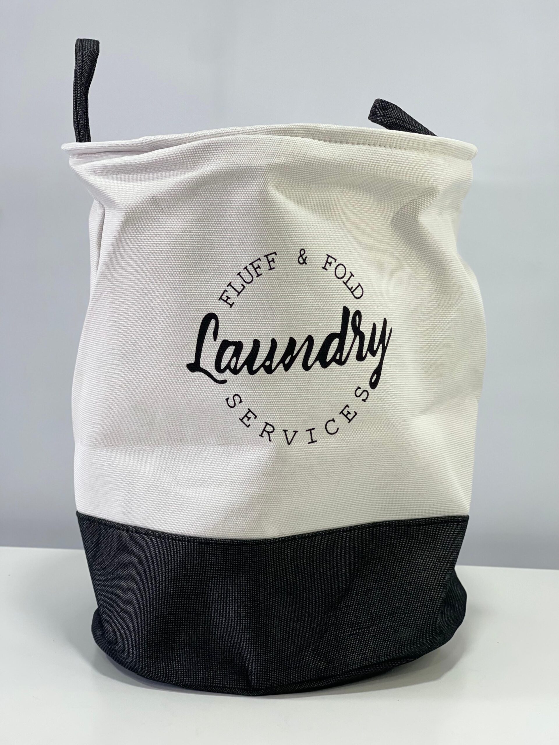 Cesto de tela para ropa sucia, blanco y gris, con texto "Laundry Services", ideal para organizar el hogar.