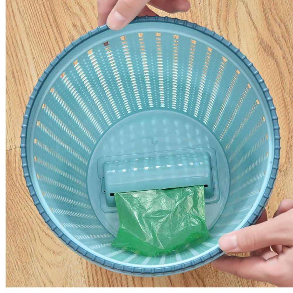 Papelera azul con dispensador de bolsas verdes, diseño calado, ideal para mantener higiene.