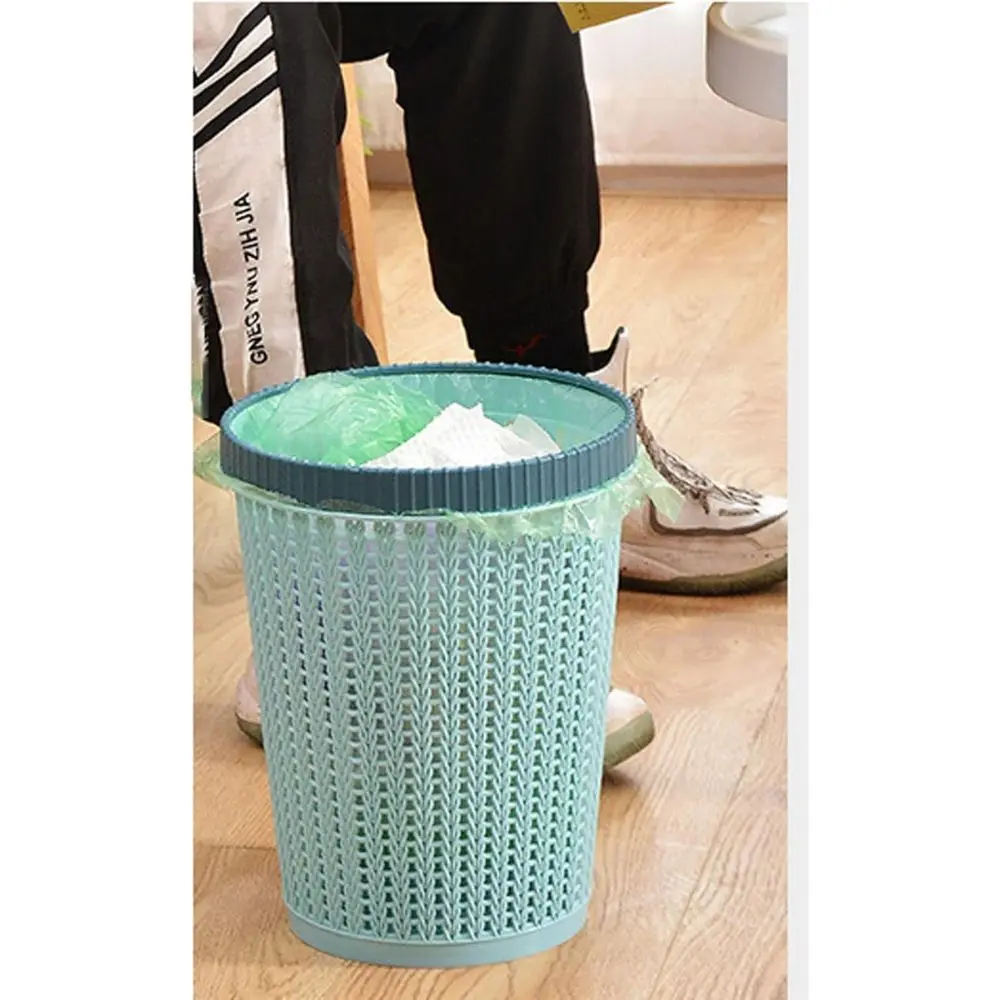 Papelera de plástico tejida color menta con borde azul, con bolsa verde y papel dentro.