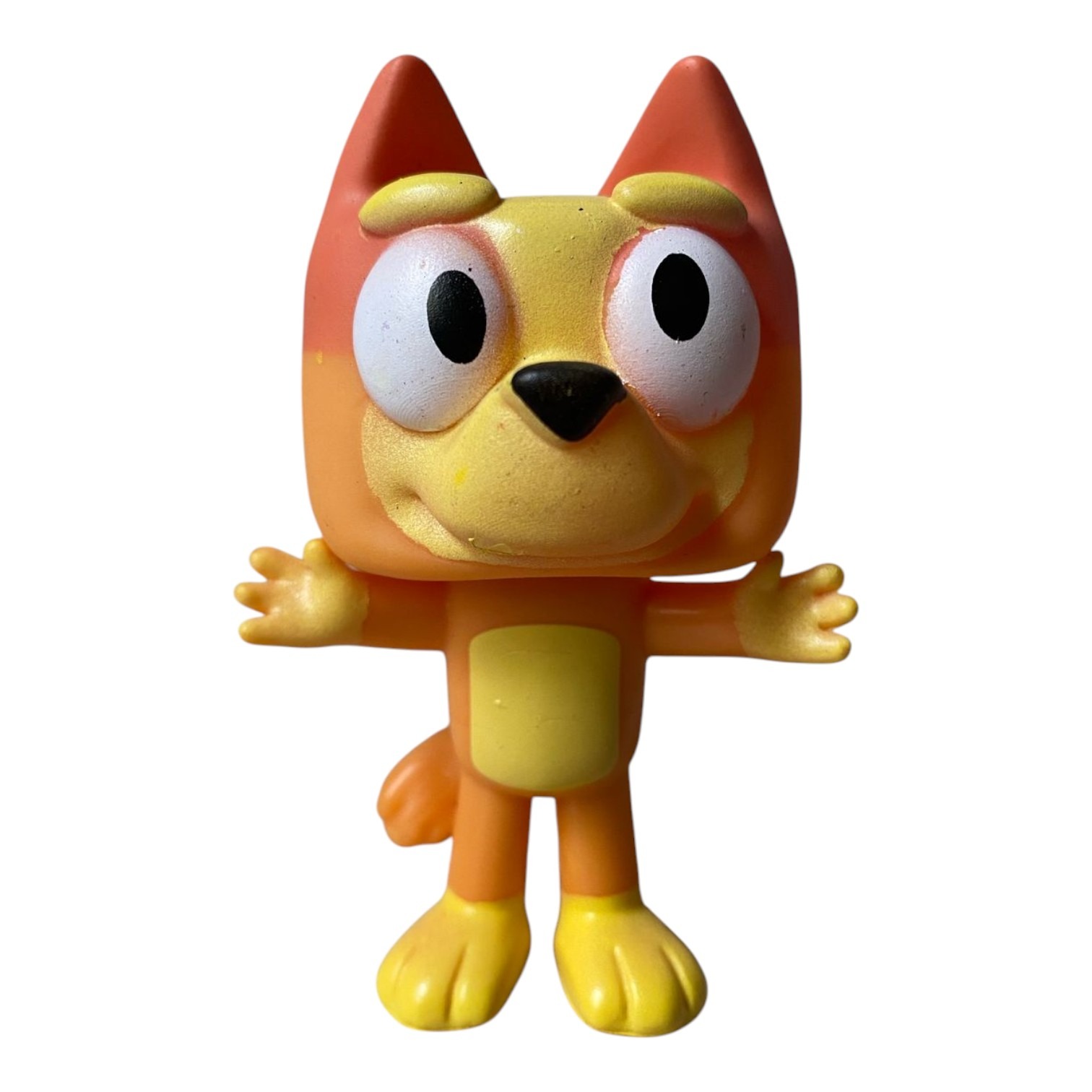 Figura decorativa de Bingo, naranja y amarilla, con ojos grandes y brazos extendidos.
