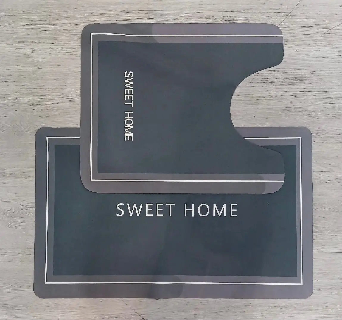 Tapetes duo absorbentes gris oscuro con borde blanco y texto "SWEET HOME".