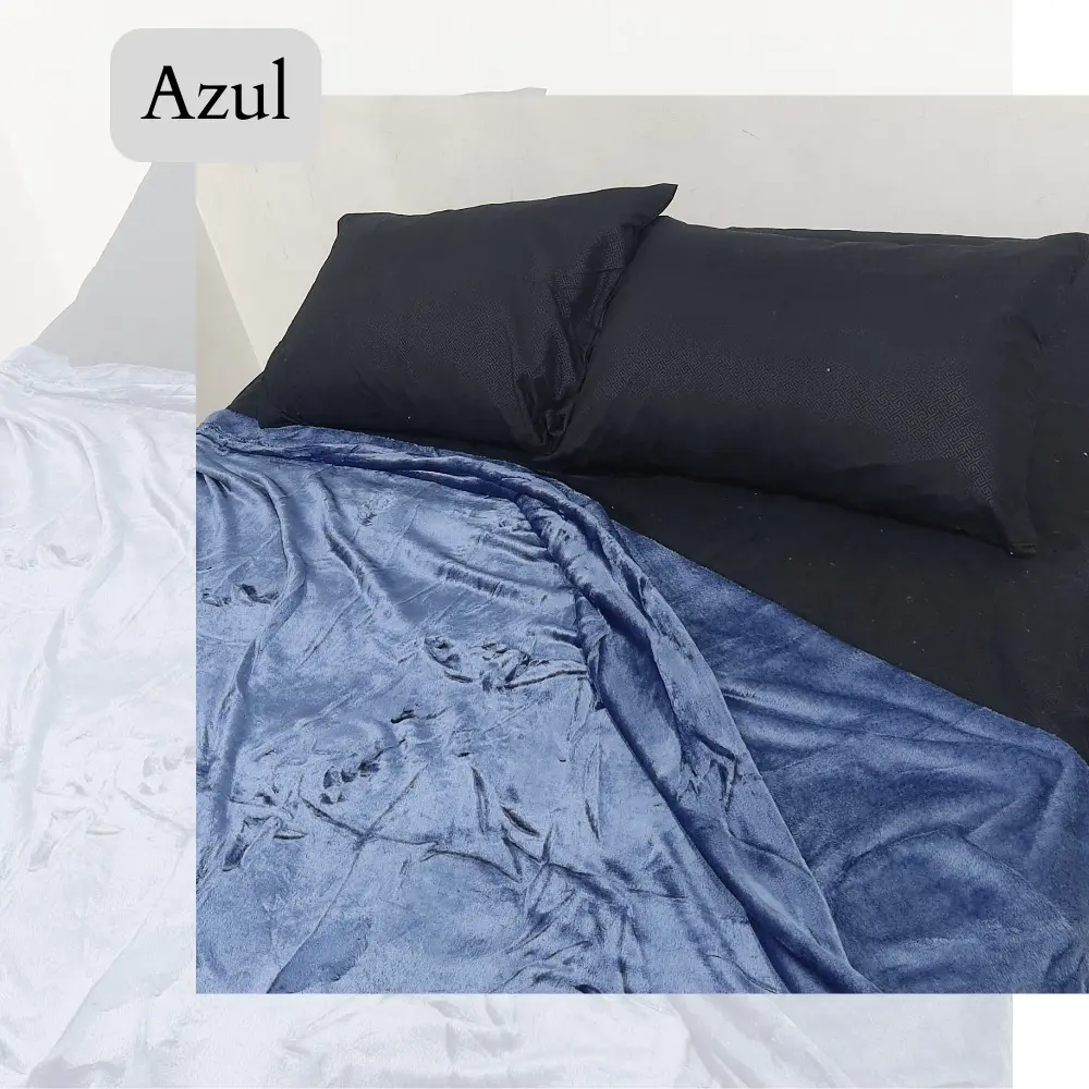 Cobija Piel de Durazno 1.40 color azul, con textura suave, sobre cama con almohadas negras.