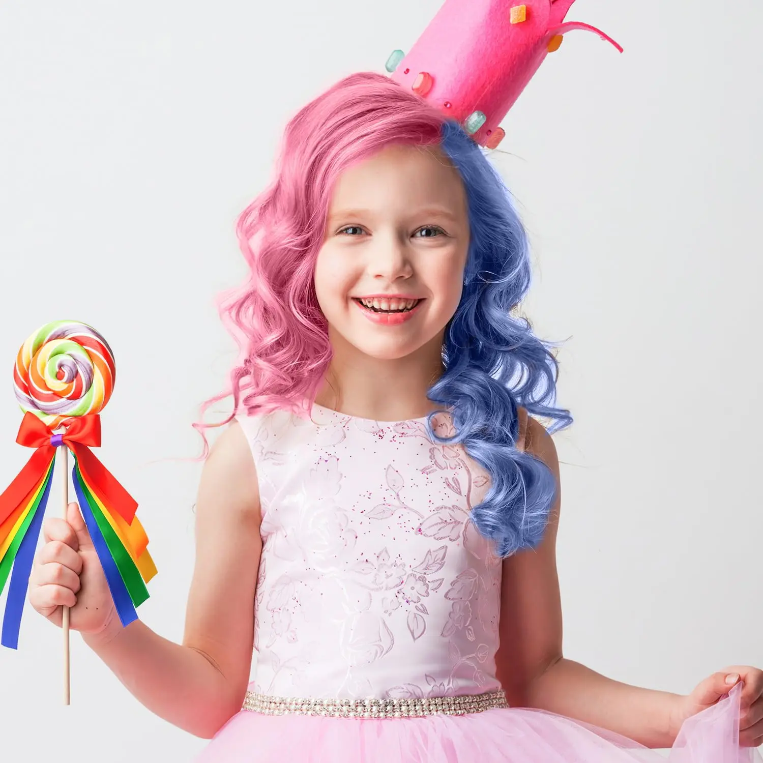 Niña con cabello rosa y azul, corona rosa y vestido, sostiene paleta de colores arcoíris.