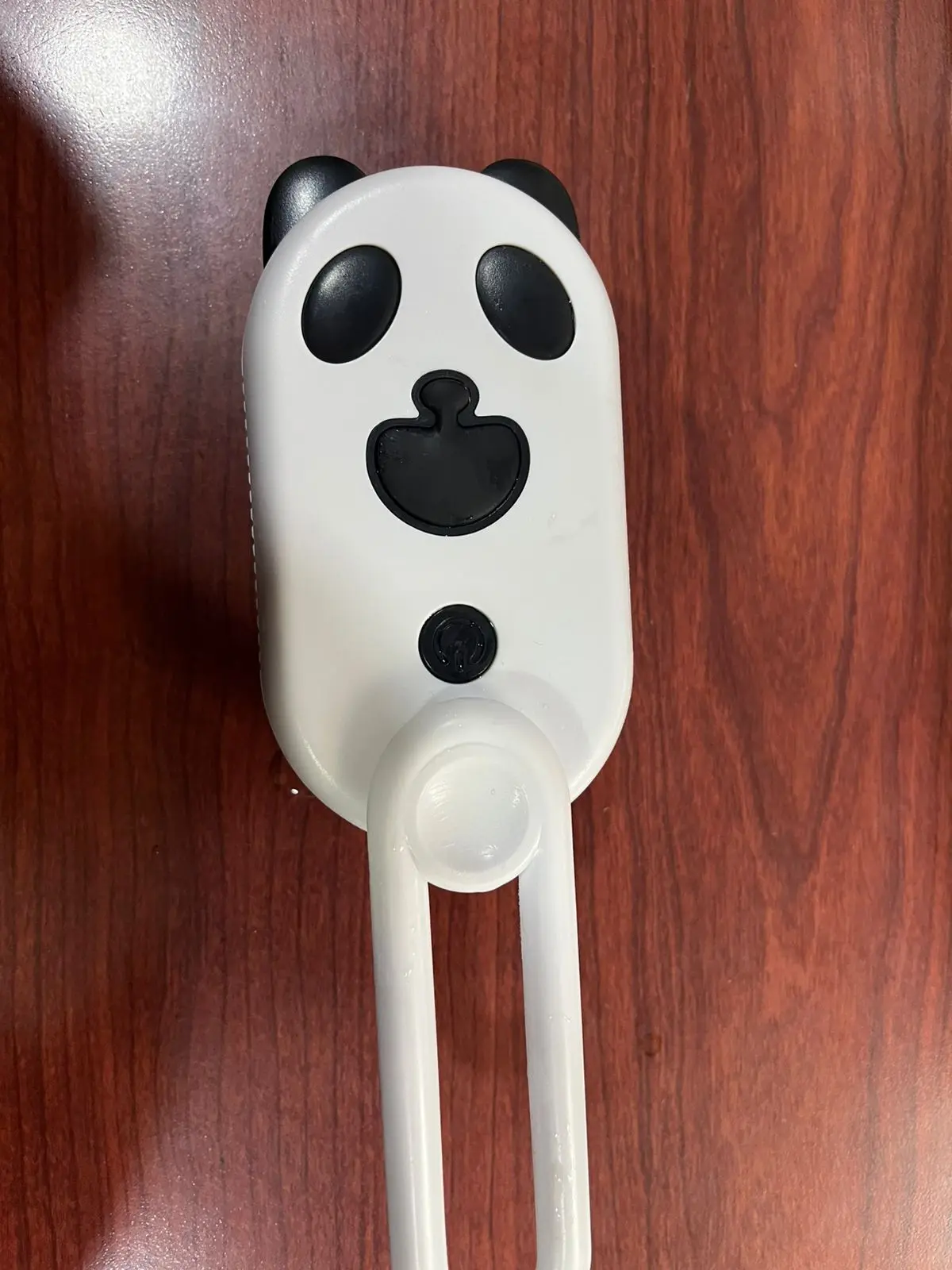 Cepillo para mascotas tipo panda con vapor, blanco y negro, con brazo articulado de sujeción.