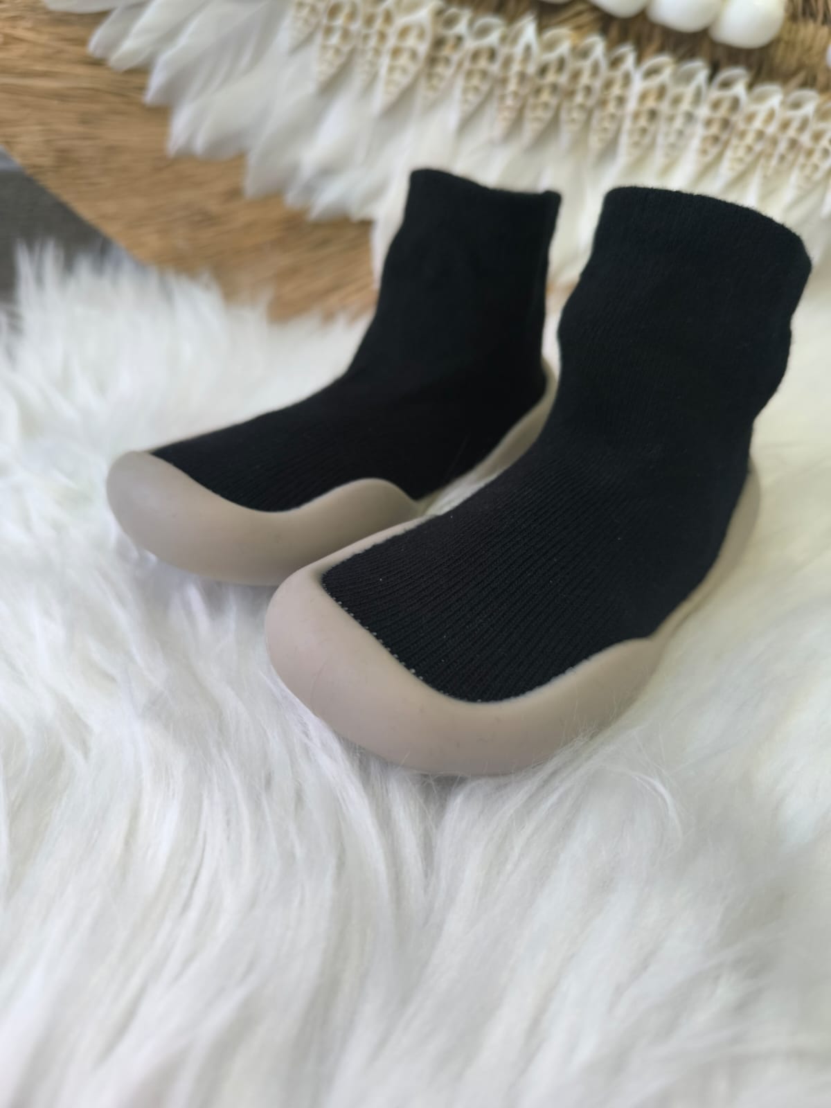 Zapatos respetuosos negros para bebé con suela beige, estilo botín, ideales para primeros pasos.