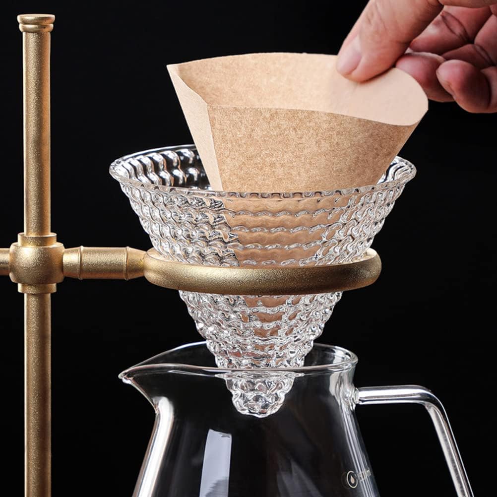 Filtro de café V60 #2 en papel marrón, para cafetera de goteo, con soporte dorado y jarra de vidrio.