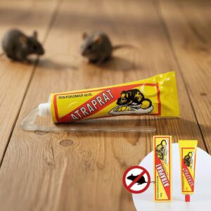 Tubo de pegante para ratas Atrapra, amarillo con rojo, y dos cajas pequeñas con el mismo pegante, sobre madera.