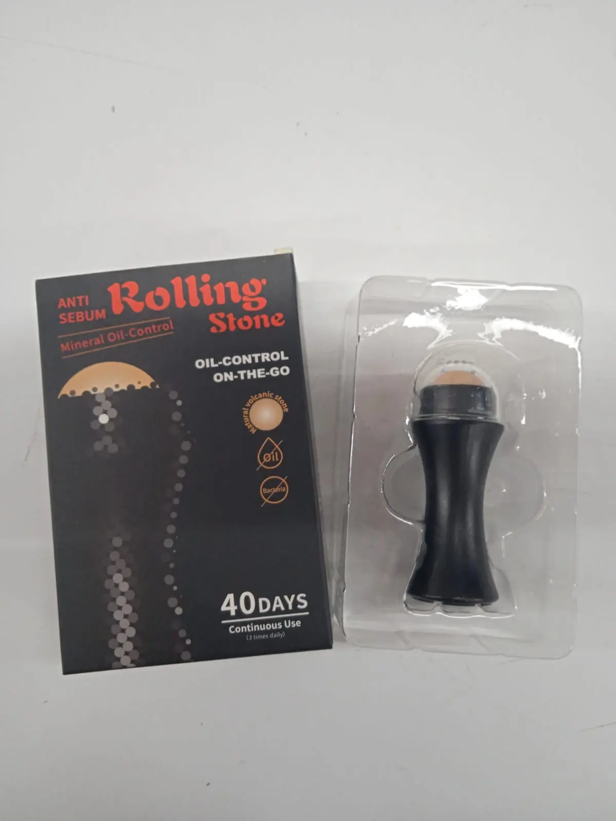 Roll-on quita grasa portátil negro con piedra volcánica, ideal para control de brillo facial.