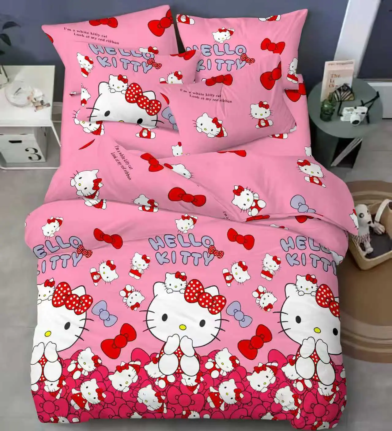 Juego de sábanas infantiles rosadas con estampado de Hello Kitty y lazos rojos, ideal para cama.