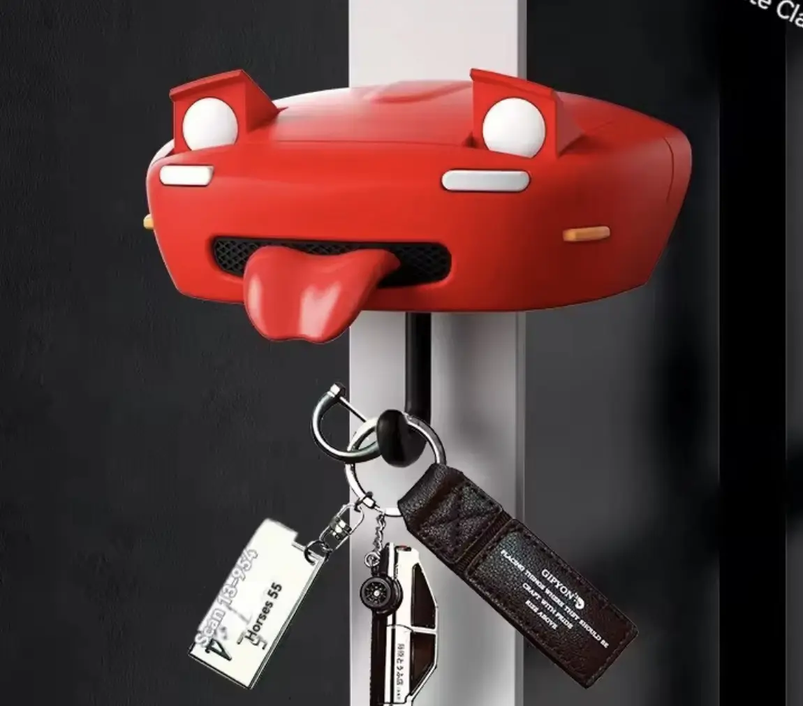 Gancho para llaves rojo con forma de auto deportivo y lengua afuera, sostiene llaveros.