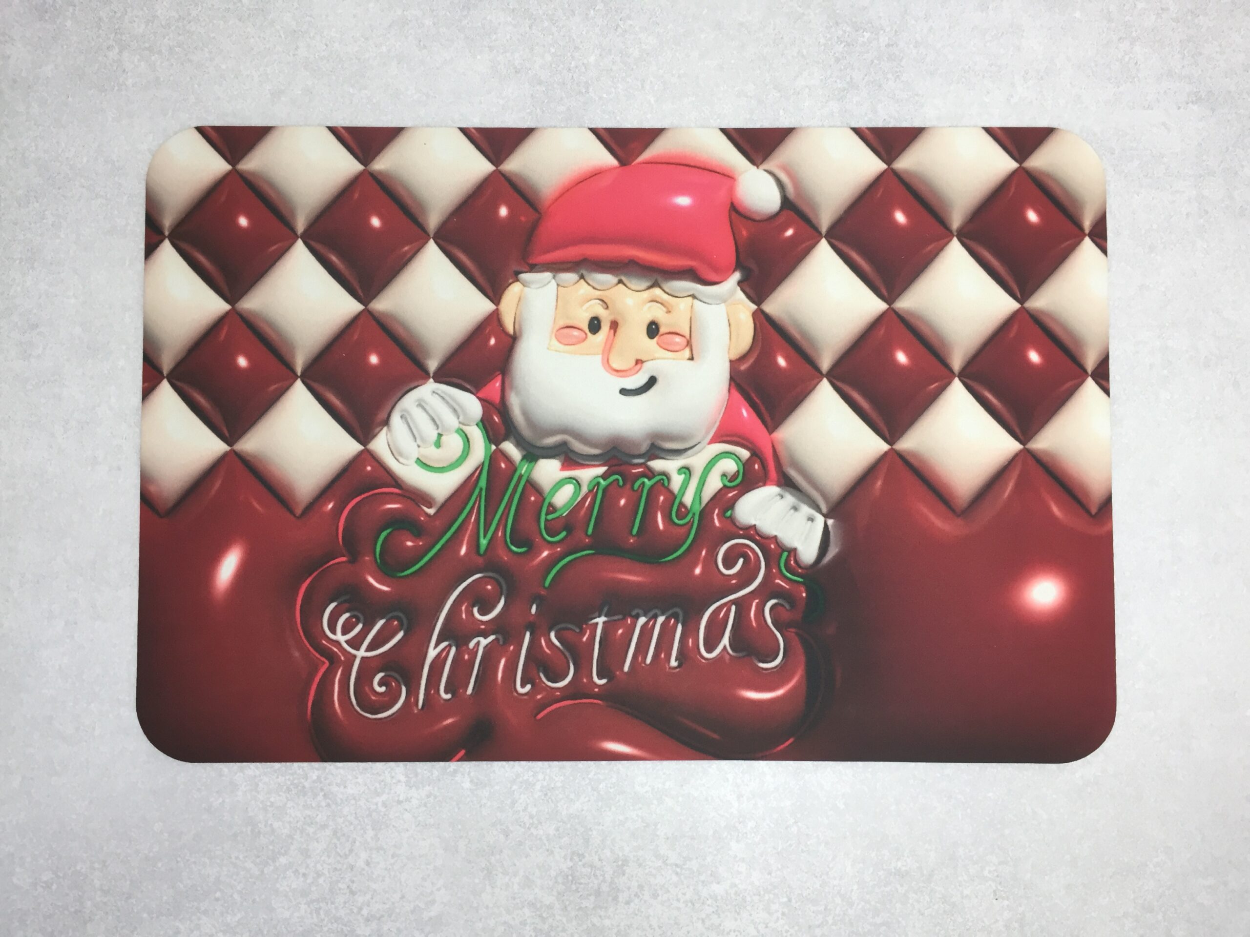 Set de 2 tapetes absorbentes con diseño navideño de Santa Claus y texto "Merry Christmas" en relieve rojo y verde.