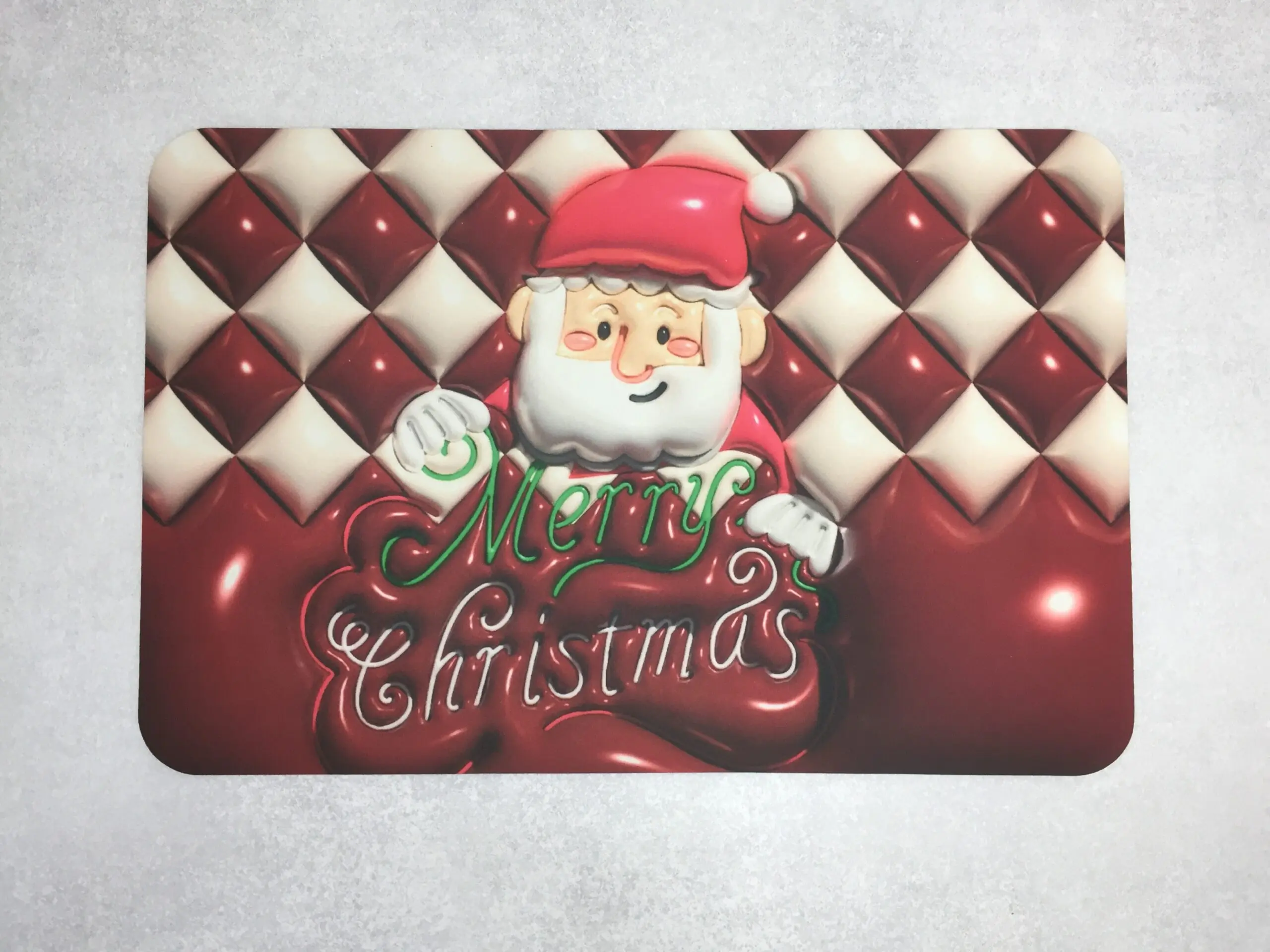 Set de 2 tapetes absorbentes con diseño navideño de Santa Claus y texto "Merry Christmas" en relieve rojo y verde.