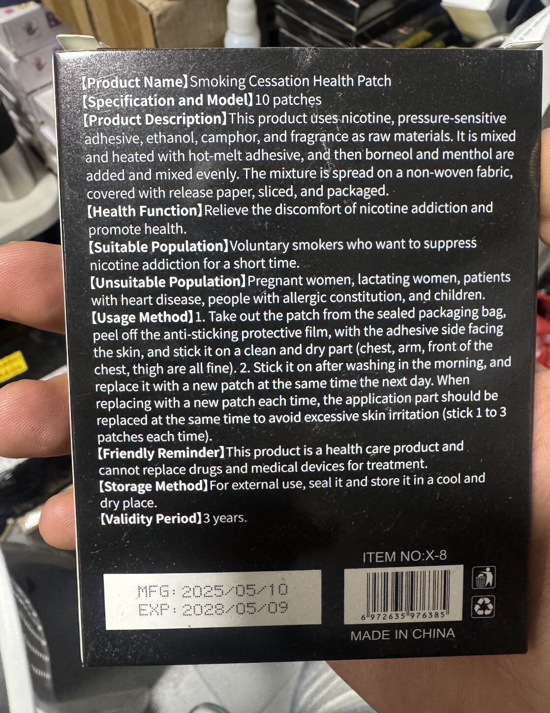 Parches para dejar de fumar, caja negra con instrucciones y fechas de fabricación/vencimiento.