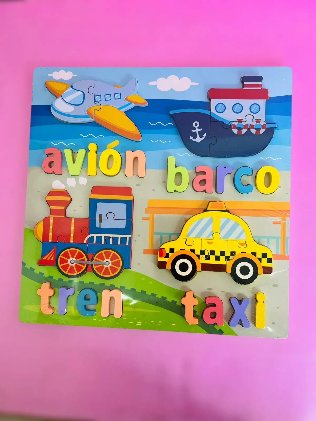 Didáctico de madera con 4 medios de transporte y sus nombres: avión, barco, tren y taxi. Colores vivos.