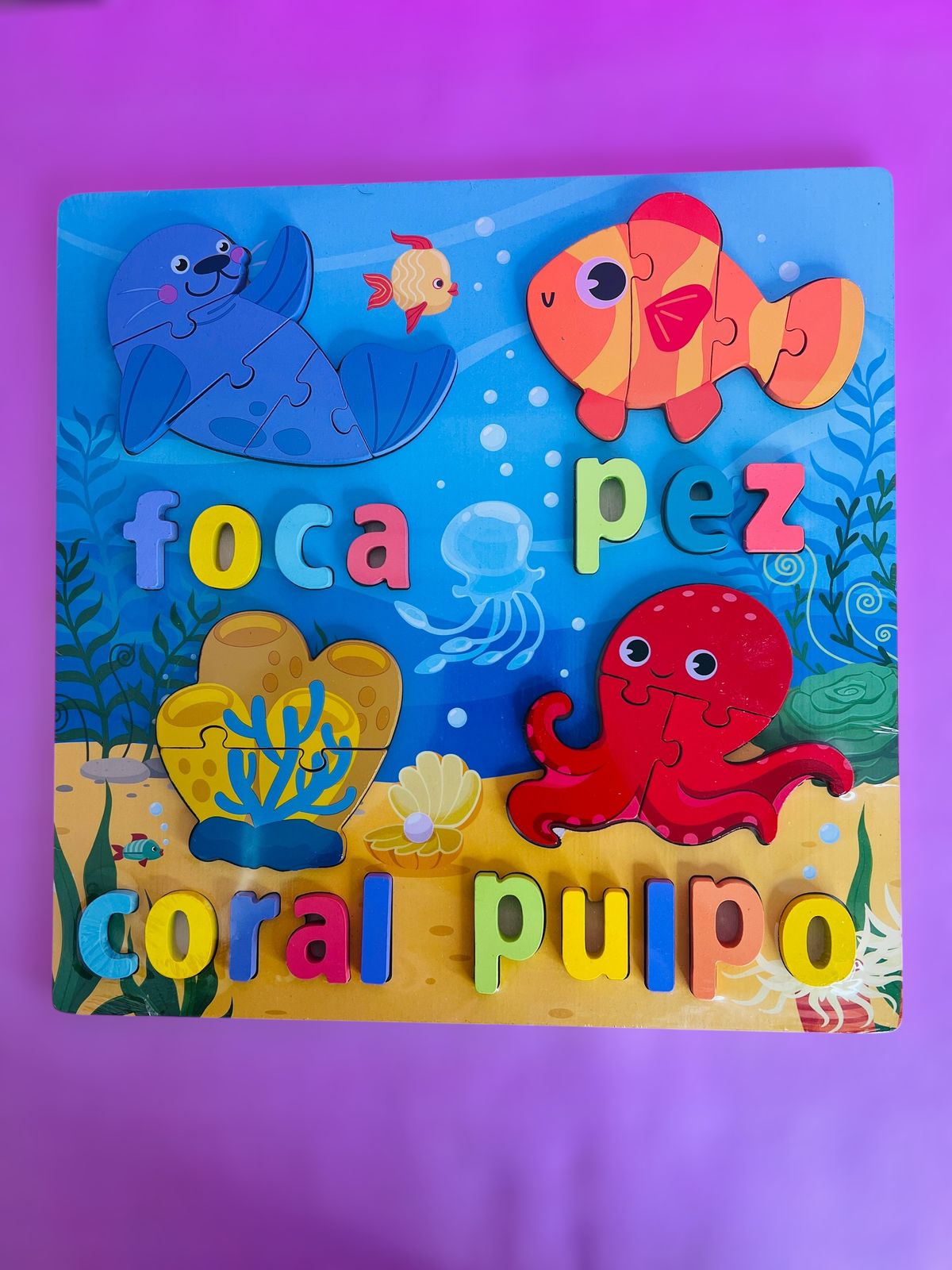 Didáctico de madera con figuras marinas y letras de colores "foca", "pez", "coral", "pulpo".