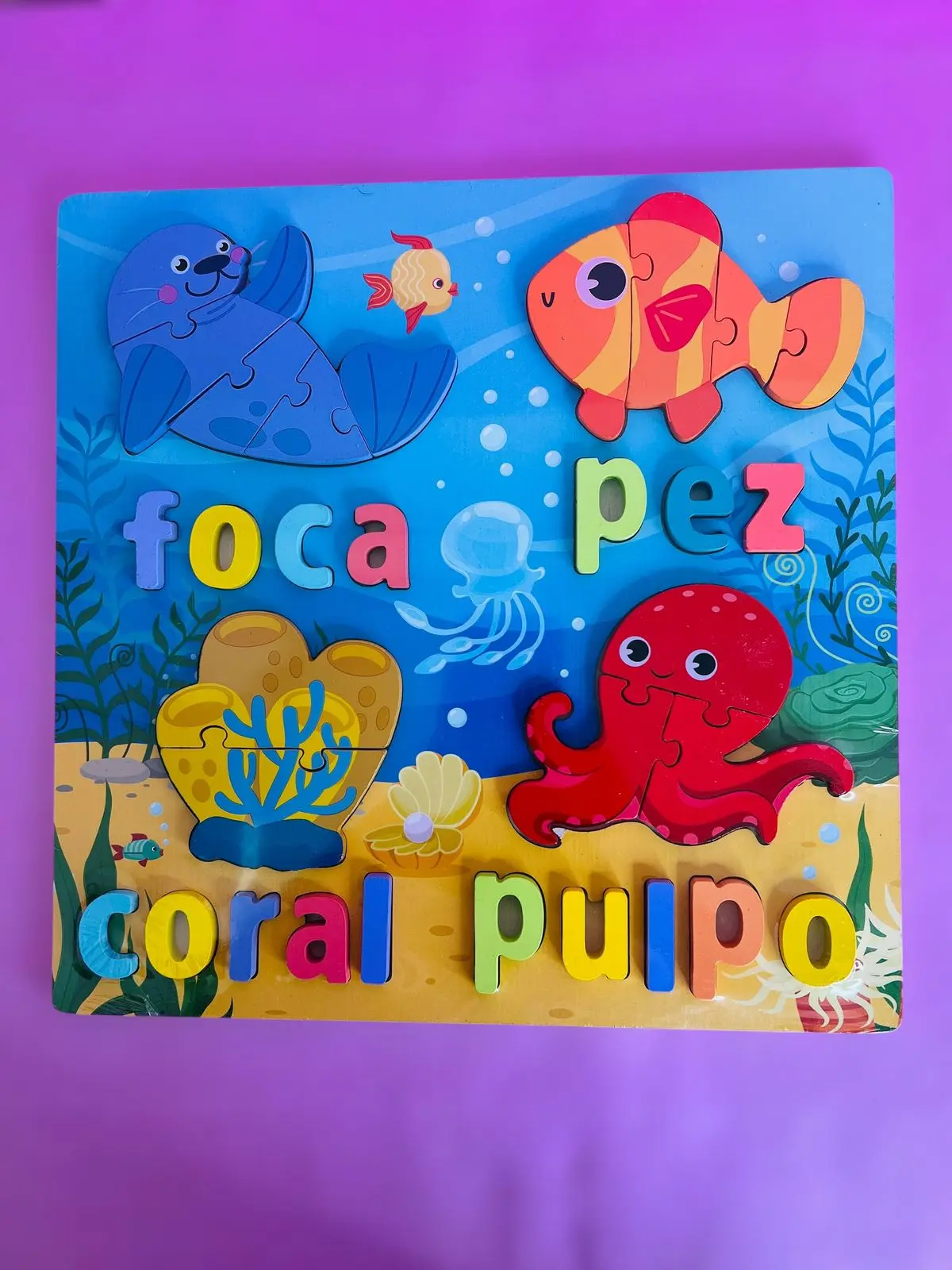 Didáctico de madera con figuras marinas y letras de colores "foca", "pez", "coral", "pulpo".