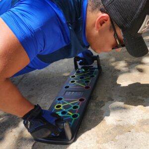 Hombre entrenando tren superior con tabla push up plegable multifuncional en exterior.