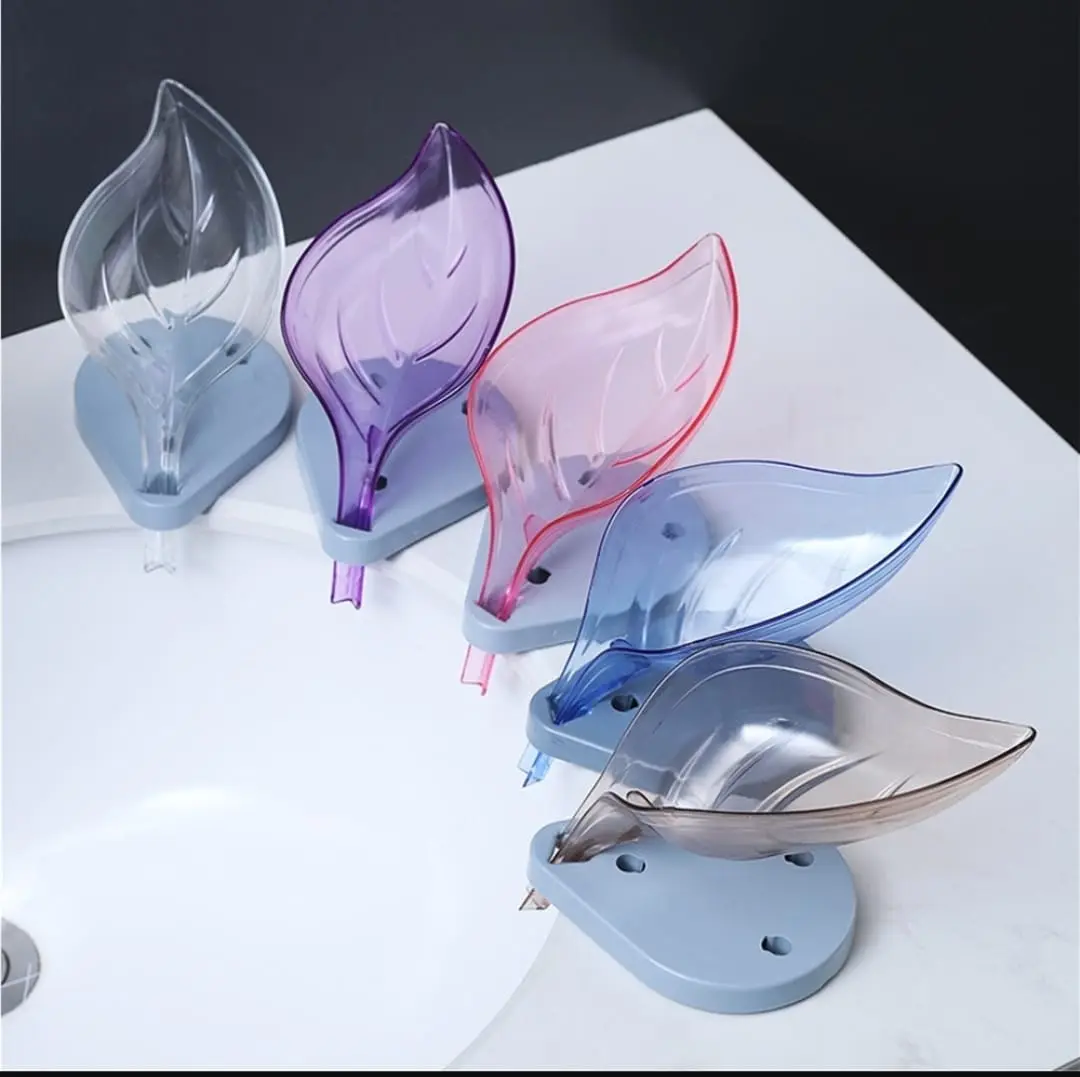 Jaboneras de plástico en forma de hoja de colores: transparente, morada, rosa, azul y marrón, con base gris y drenaje, para baño y cocina.