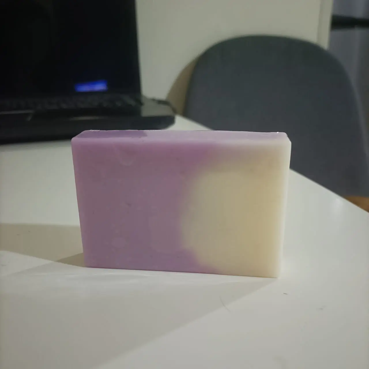 Jabón artesanal de avena y lavanda, barra bicolor lila y crema, con acabado suave.