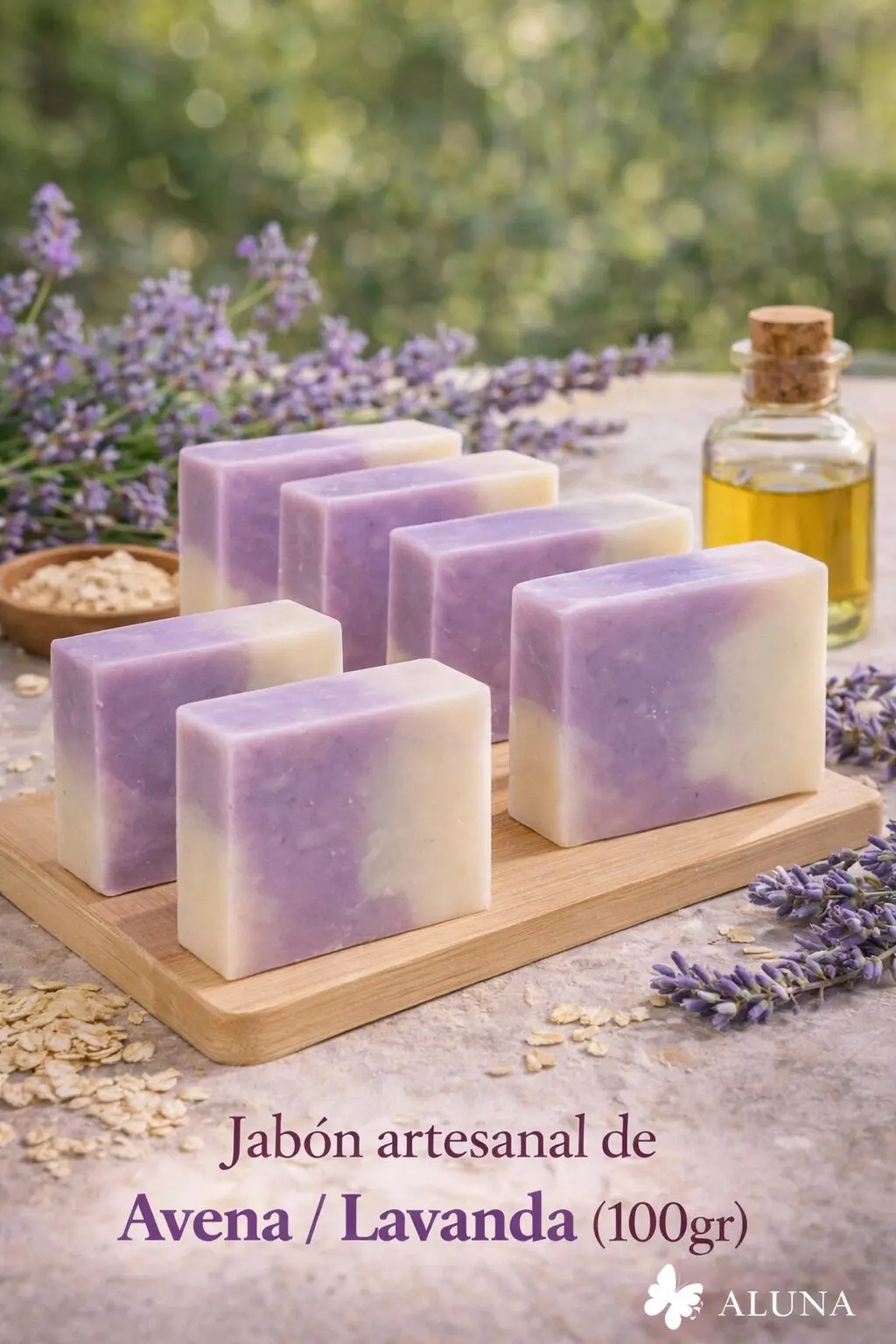 Jabones artesanales de avena y lavanda en dos tonos, sobre tabla de madera, con flores de lavanda y frasco de aceite.