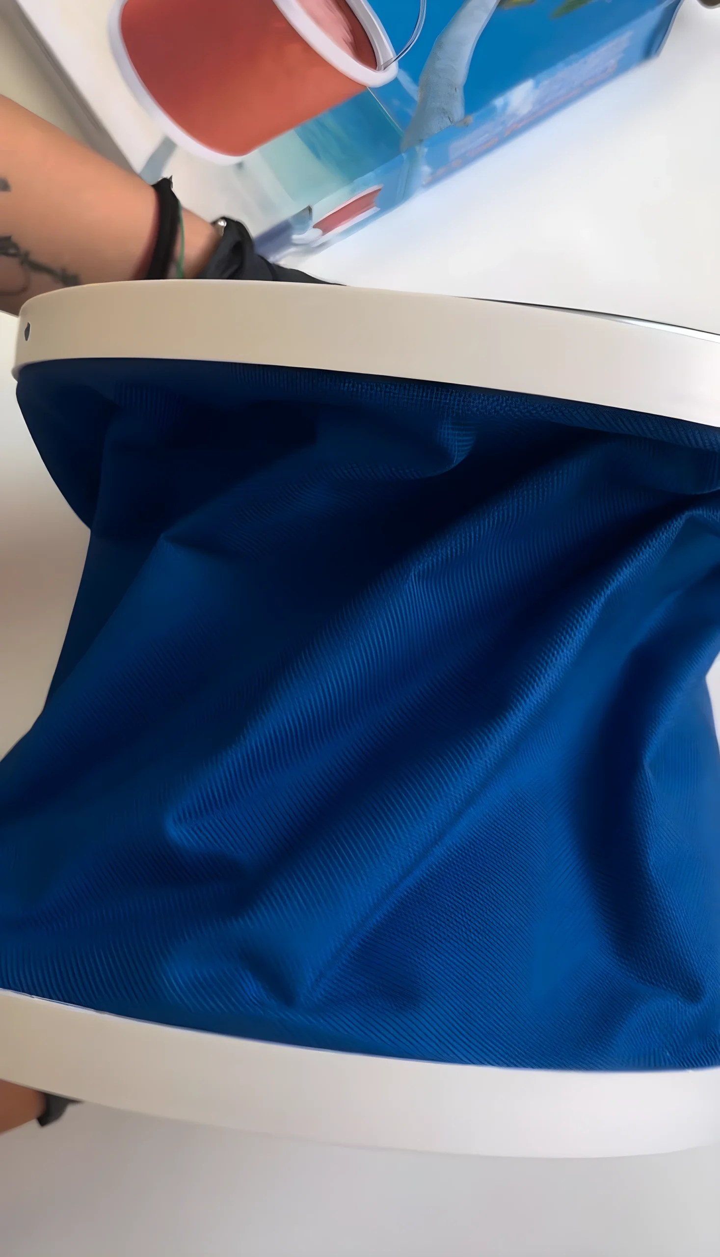 Balde plegable azul de tela texturizada, con borde blanco, útil para transportar agua.