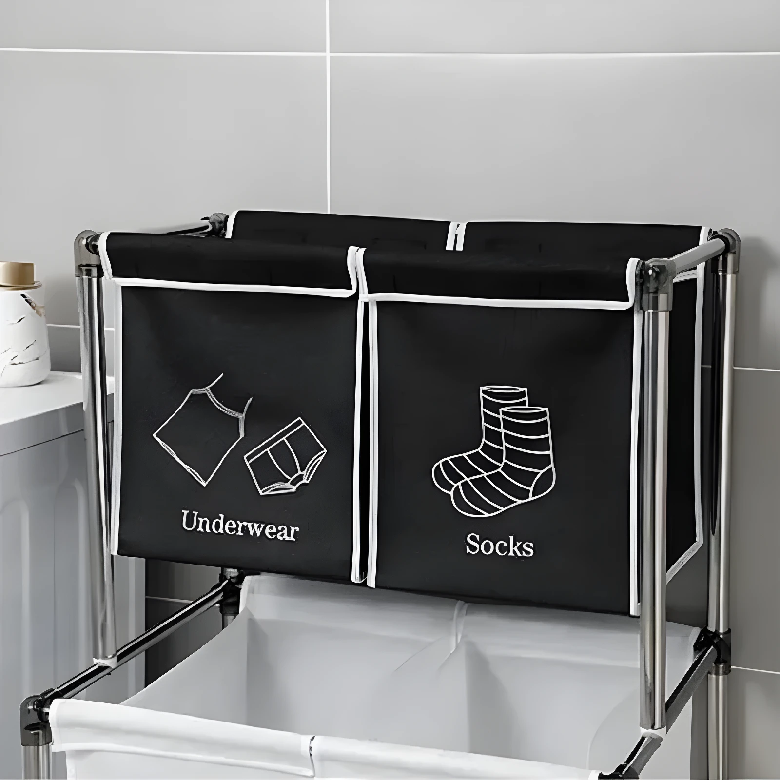 Cesta para ropa sucia negra de 2 divisiones, "Underwear" y "Socks", con estructura metálica.