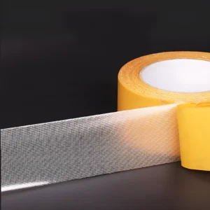 Cinta doble faz transparente con malla, ideal para pegar objetos sin dañar superficies.