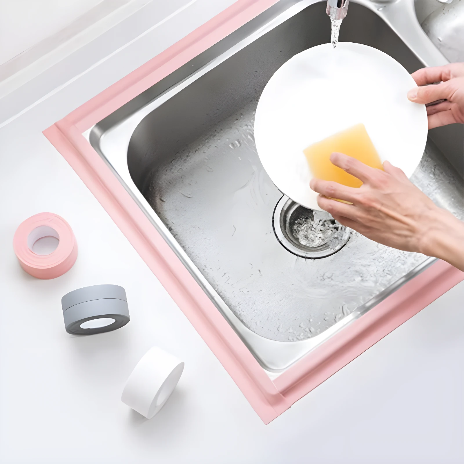 Cinta selladora adhesiva impermeable rosa y gris para borde de lavaplatos, con plato blanco y esponja amarilla.