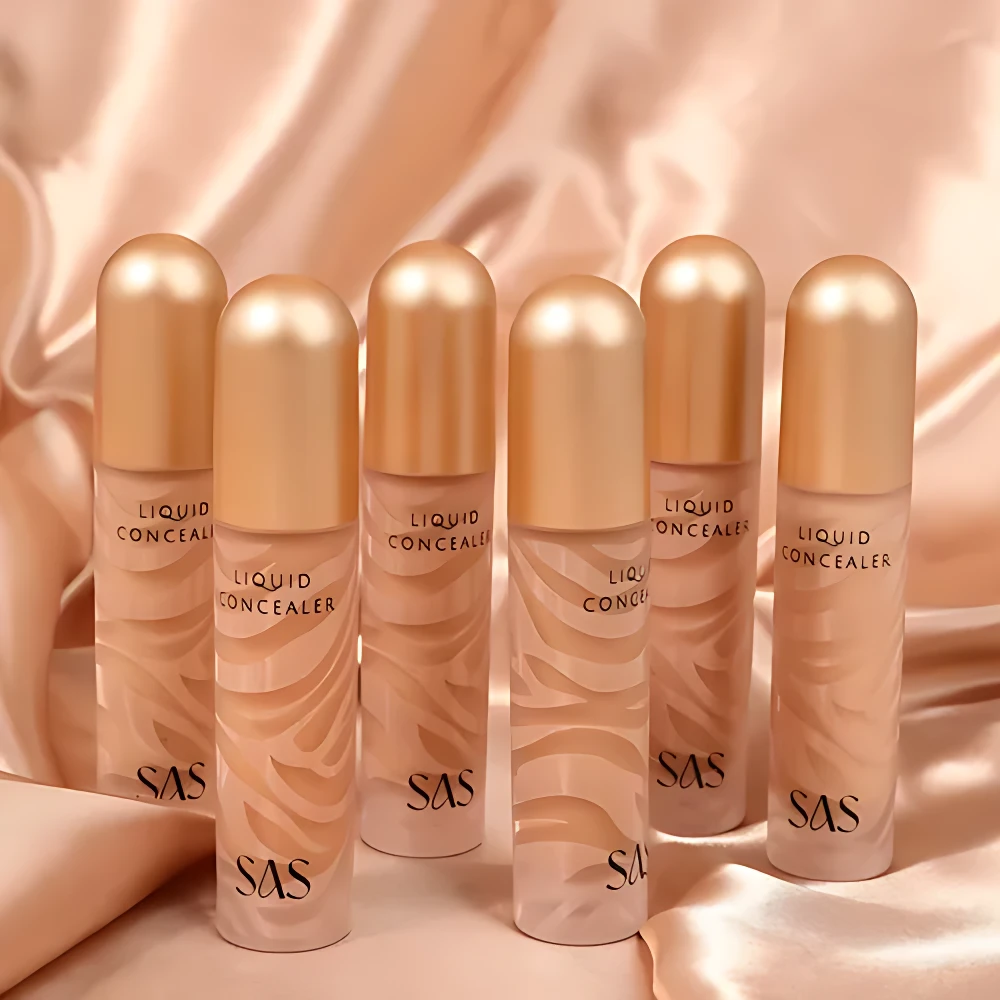 Set x2 correctores líquidos SAS alta cobertura en frascos transparentes con tapas doradas y diseño de ondas.