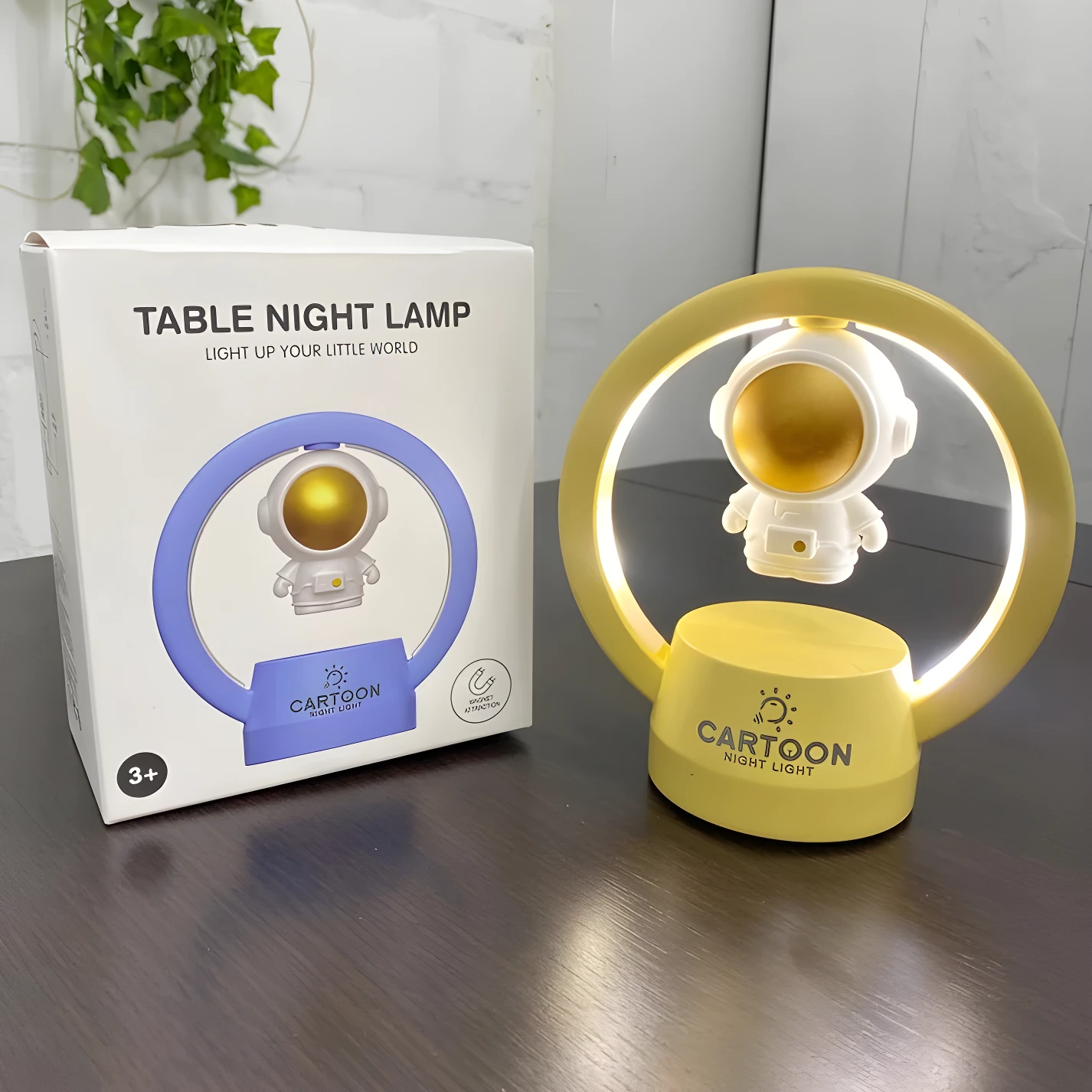 Lámpara de mesa LED astronauta flotante, base amarilla, aro brillante, ideal para niños.
