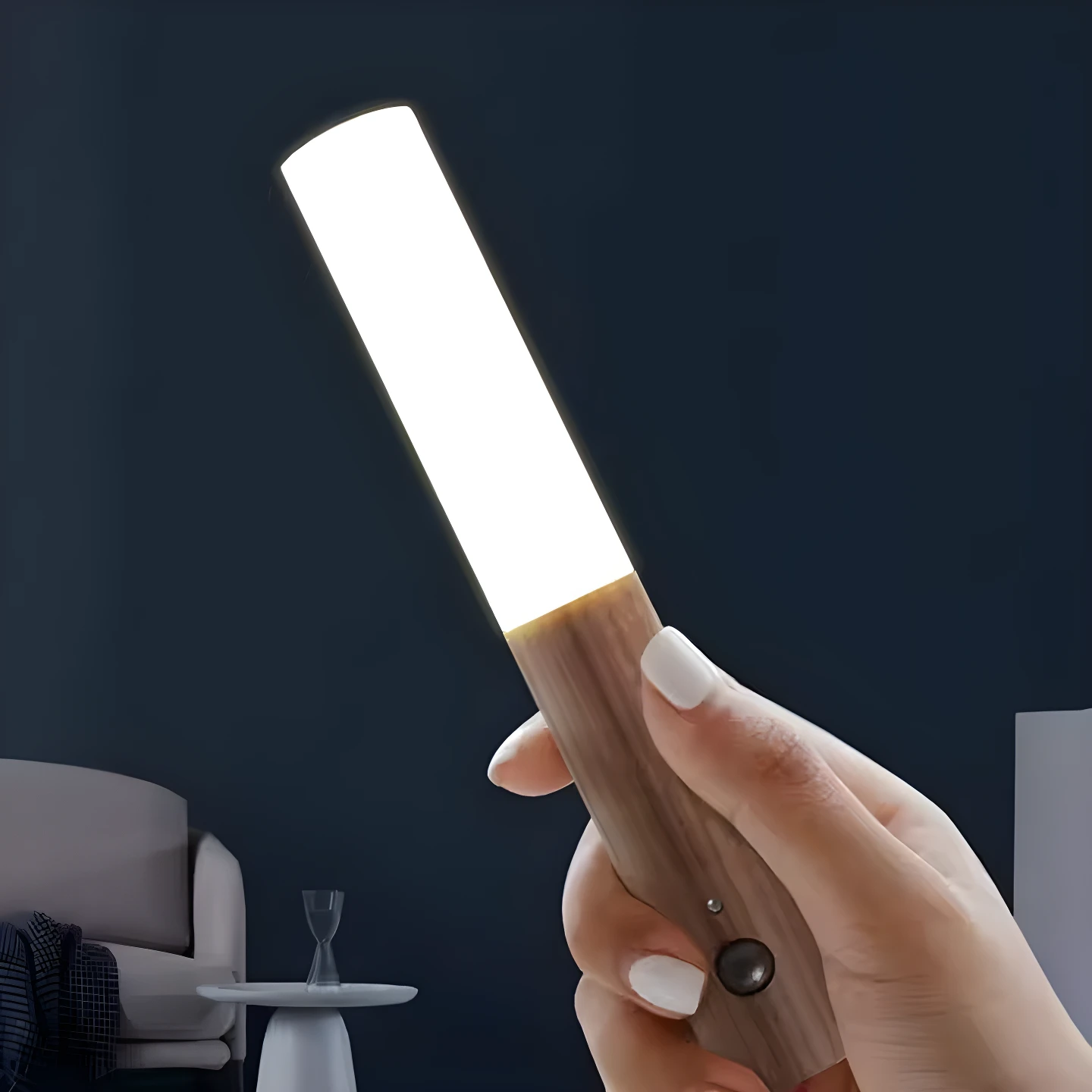 Lámpara LED portátil madera con sensor de movimiento, sostenida en mano, ilumina espacio oscuro.