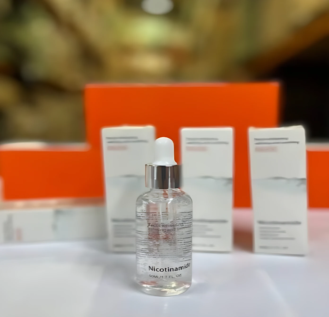 Serum Niacinamida en frasco de vidrio con gotero, fondo naranja, 30ml.