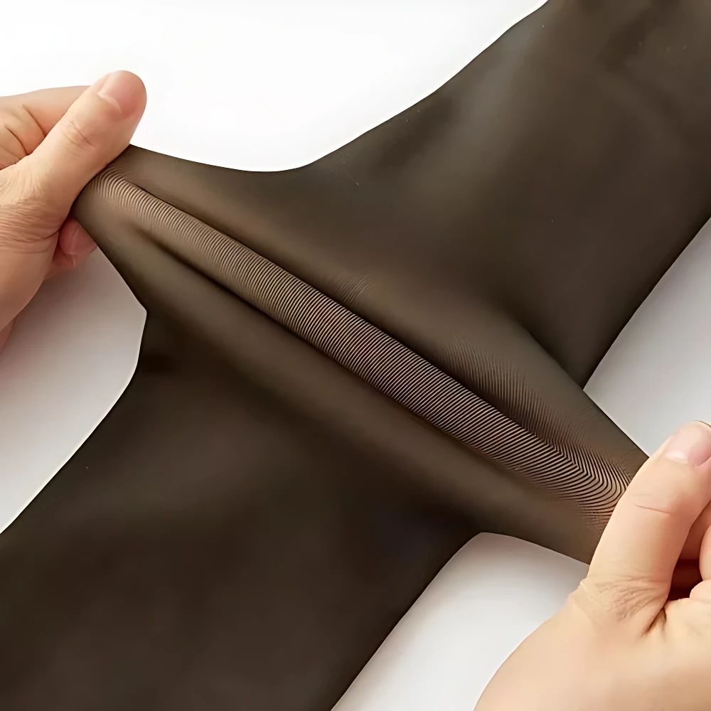 Medias térmicas oscuras translúcidas de terciopelo, estiradas para mostrar textura acanalada.