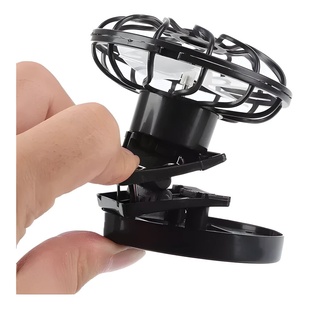 Mini ventilador solar negro para gorra, sujeto con pinza a mano.