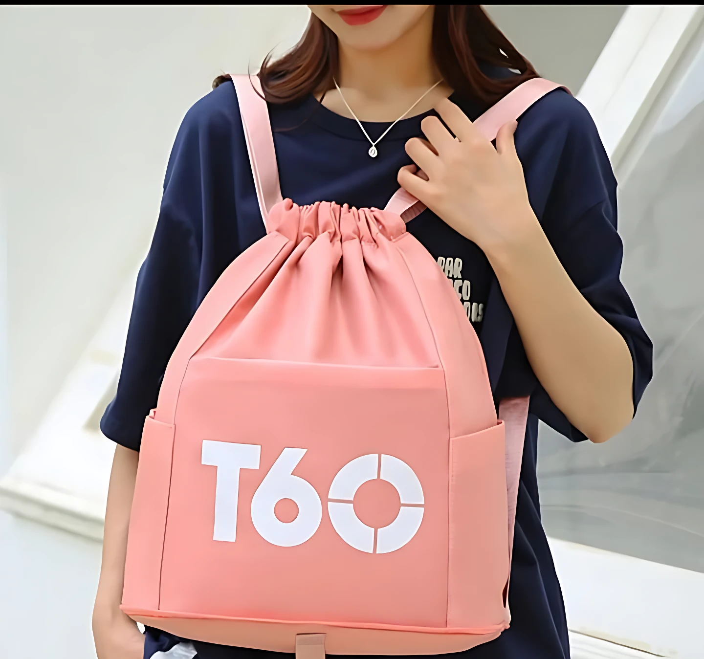 Mochila deportiva rosa de nylon con logo T60, ideal para uso casual y organizado.