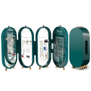 Organizador de joyas verde plegable con espejo, exhibe collares y aretes en sus compartimentos transparentes.