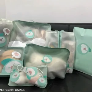 Set de 7 organizadores viajeros para niños con diseño de pingüino, en tonos menta, ideales para clasificar ropa y juguetes en maletas.