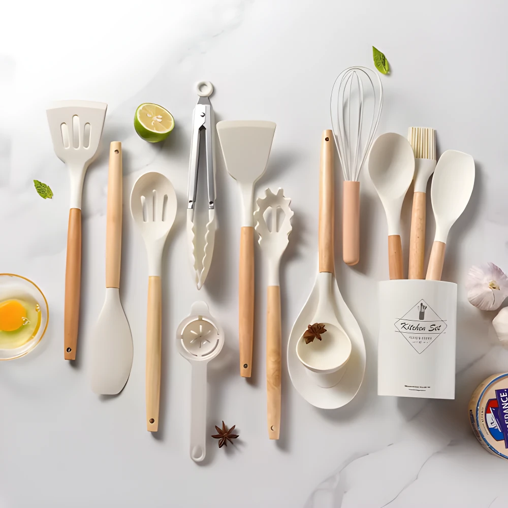 Set de 12 utensilios de cocina en silicona blanca con mangos de madera, incluye batidor, espátulas y pinzas, perfectos para uso antiadherente.