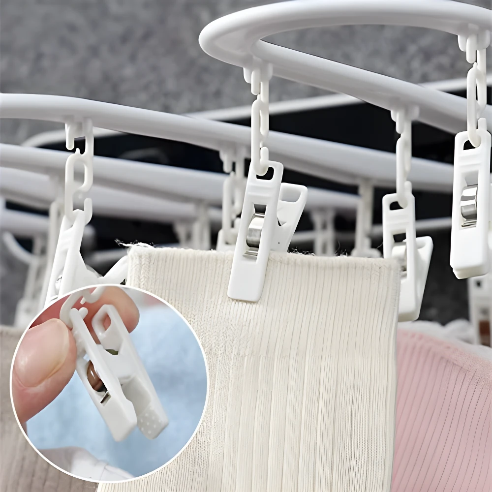 Tendedero blanco plegable con clips para colgar ropa, ideal para secar prendas en espacios reducidos.