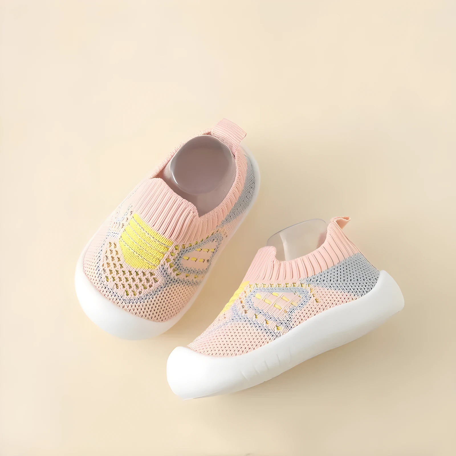 Zapatos infantiles rosados con suela blanca, diseño de malla transpirable con detalles en amarillo y gris, para correr.